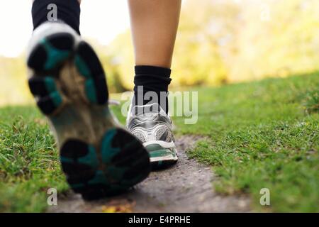 I piedi di un runner nel parco. Donna che cammina nel parco, in prossimità dei piedi. Fitness e di esercitare la formazione. Foto Stock