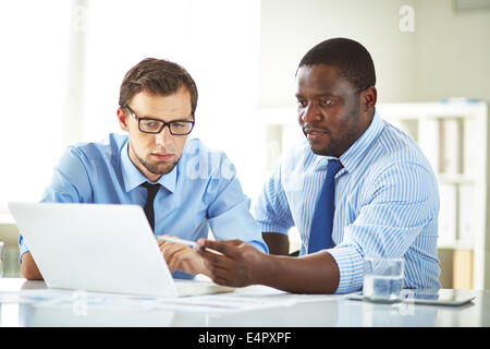 Immagine di due giovani imprenditori utilizzando laptop e interagire in riunione Foto Stock