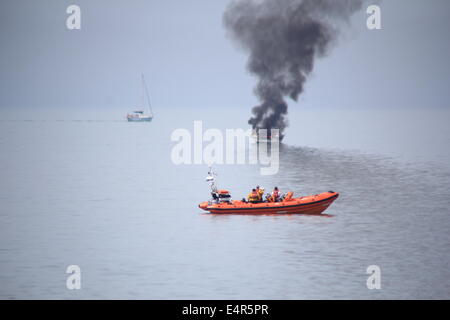 Xvi maggio 2014 cabinato di foschia marina venne inghiottito in fiamme al largo della costa di Aberystwyth, un uomo è stato salvato dal RNLI Foto Stock