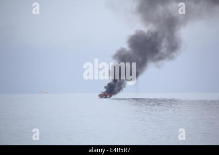 Xvi maggio 2014 cabinato di foschia marina venne inghiottito in fiamme al largo della costa di Aberystwyth, un uomo è stato salvato dal RNLI Foto Stock