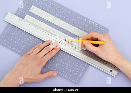 Il taglio del nastro adesivo protettivo per le dimensioni per creare stencil per cornice immagine Foto Stock