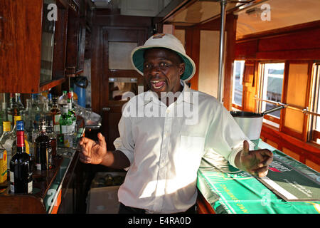 Esuberante barista nel midollo hat colpisce una posa a bordo di una locomotiva appartenente alla società nazionale delle ferrovie dello Zimbabwe Foto Stock