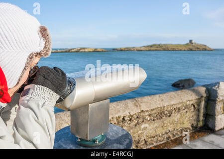 Giovane donna utilizzando un gettone telescopio Foto Stock