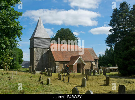 Giardiniere soffiaggio di erba tagliata presso la chiesa di San Pietro, Liss, East Hampshire, Inghilterra, Regno Unito Foto Stock