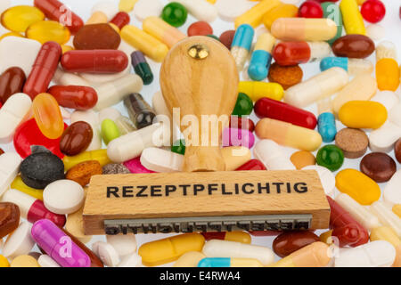 Timbro su compresse di colore, foto simbolico per farmaci, Rezeptflicht e pagamento supplementare, Stempel auf bunten Tabletten, Symbolfo Foto Stock