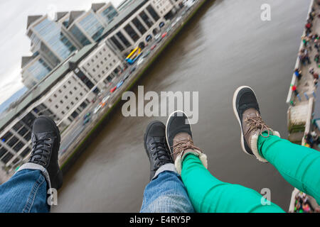 Piedi oltre il fiume Liffey a Dublino con Ulster Bank sullo sfondo Foto Stock