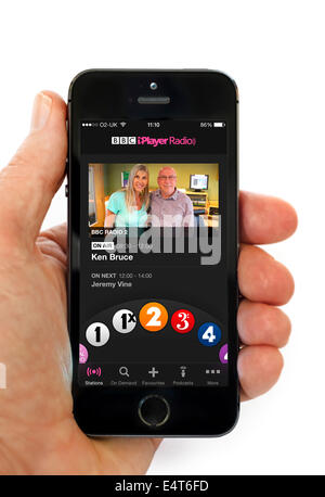 Ascolto di Ken Bruce mostra tramite la BBC iPlayer app Radio su un Apple iPhone 5S, REGNO UNITO Foto Stock