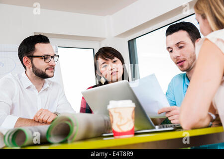 Close-up di un gruppo di giovani uomini di affari che seduti attorno al tavolo, di incontro e di discussione, Germania Foto Stock