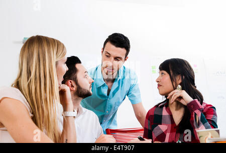 Un gruppo di giovani uomini di affari che incontro e in discussione in ufficio, Germania Foto Stock