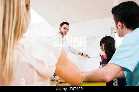 Un gruppo di giovani uomini di affari che incontro e in discussione in ufficio, Germania Foto Stock