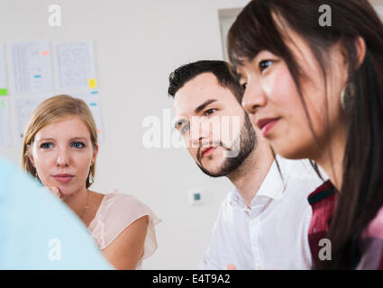 Close-up di un gruppo di giovani uomini di affari che incontro e in discussione in ufficio, Germania Foto Stock