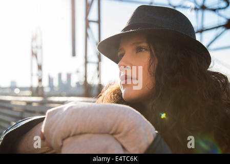 Close-up ritratto di ragazza adolescente all'aperto, indossando fedora e guardando in lontananza, Germania Foto Stock