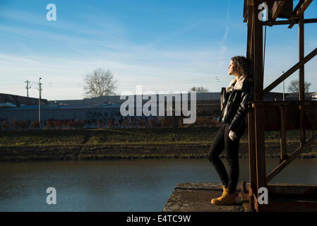 Ragazza adolescente in piedi sul dock commerciale all'aperto, guardando in lontananza, Germania Foto Stock