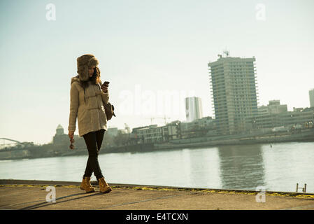 Ragazza adolescente all'aperto, camminando lungo il fronte mare di banchina di carico, Mannheim, Germania Foto Stock