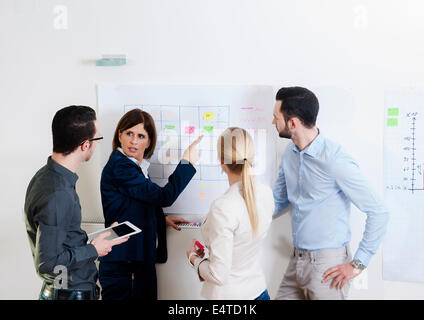 Un gruppo di giovani uomini d affari e imprenditrice matura in discussione in ufficio, Germania Foto Stock