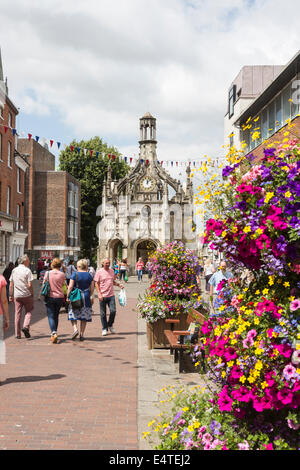 Chichester city centre e Chichester croce su una trafficata soleggiata giornata estiva con display a colori dei fiori, West Sussex, Regno Unito Foto Stock