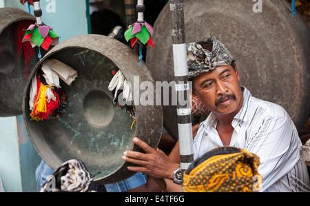 Bali, Indonesia. Indù Balinese giocando un gong in un villaggio Gamelan Orchestra. Foto Stock