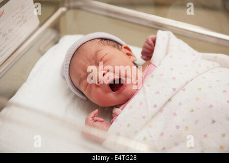Neonato ragazza sbadigli in ospedale Culla neonato Foto Stock