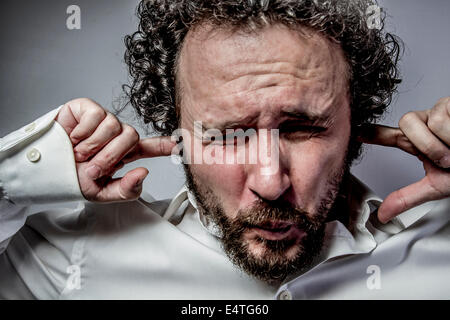 Non voglio sentire nulla, l'uomo con intensa espressione, camicia bianca Foto Stock