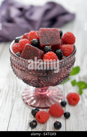 Jelly candy con frutti di bosco freschi in vaso di vetro su sfondo di legno Foto Stock