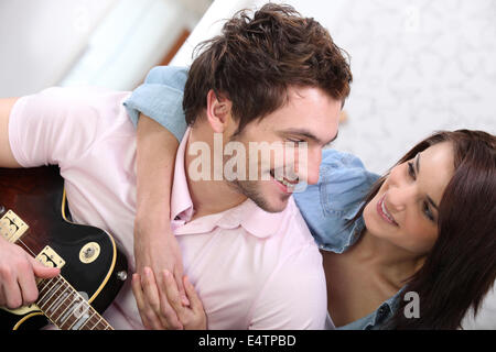 Ragazza ascoltando la chitarra guy Foto Stock