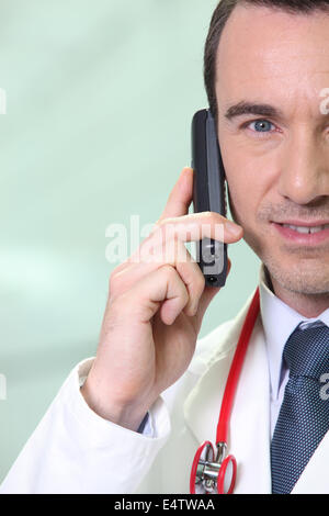 Medico maschio rendendo chiamata telefonica Foto Stock