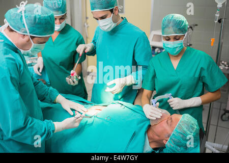 Chirurgo dando lo strumento chirurgico ad un infermiere Foto Stock