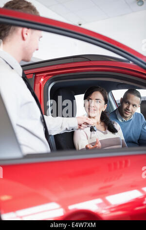 Sorridendo Il cliente riceve le chiavi dell'auto Foto Stock