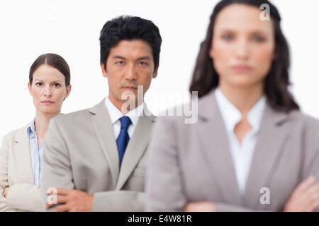 Grave salesteam in piedi con le braccia incrociate Foto Stock