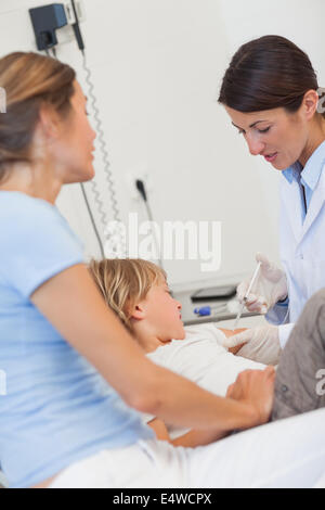 Medico serio dando bambino una iniezione Foto Stock