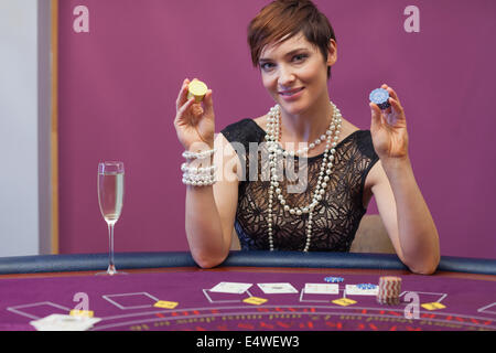 Donna al gioco del poker tenendo su chip Foto Stock