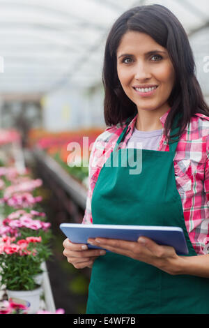 Donna di fare l'inventario in serra Foto Stock