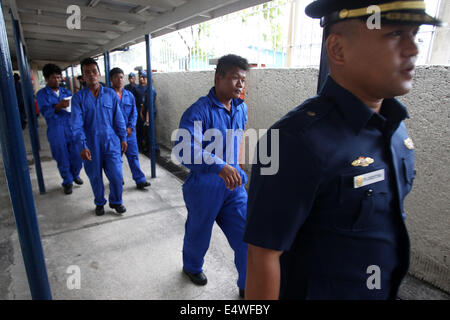 Manila, Filippine. 17 Luglio, 2014. Un membro del Philippine Coast Guard (PCG) conduce i quattro soccorse i pescatori filippino all'interno di PCG sede a Manila nelle Filippine, il 17 luglio 2014. L'equipaggio della nave cinese MV Pacific Pioneer, che proveniva da Hong Kong della Repubblica popolare cinese, ha salvato il quattro pescatori filippini che erano in mare per due giorni dopo la loro nave è stato immerso in un forte vento ha portato dal tifone Rammasun. © Rouelle Umali/Xinhua/Alamy Live News Foto Stock