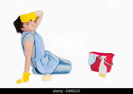 Esaurito donna la pulizia del pavimento Foto Stock