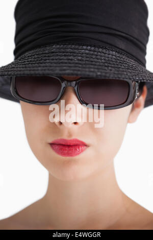 Donna che indossa un cappello e occhiali da sole Foto Stock