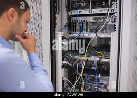 Uomo che guarda i server montati su rack Foto Stock