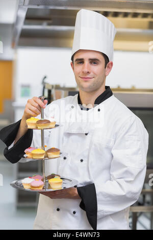 Baker holding tiered cake vassoio Foto Stock