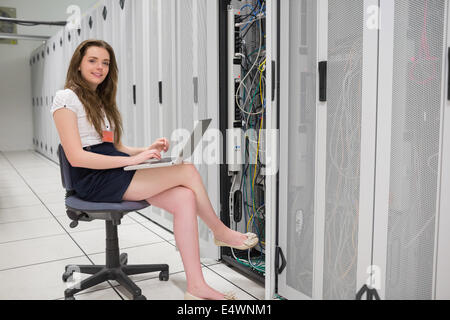 Donna sorridente facendo dello storage dei dati Foto Stock