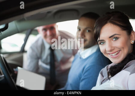 Coppia sorridente in una nuova auto Foto Stock