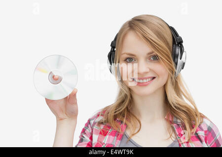 Donna che mantiene un cd mentre indossa le cuffie Foto Stock