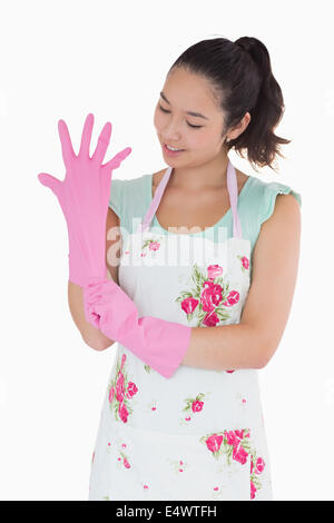 Donna tirando su guanti di gomma Foto Stock