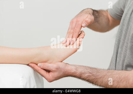 Medico tenendo il piede di un paziente Foto Stock