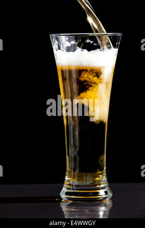 Essendo di vetro riempito con la birra Foto Stock