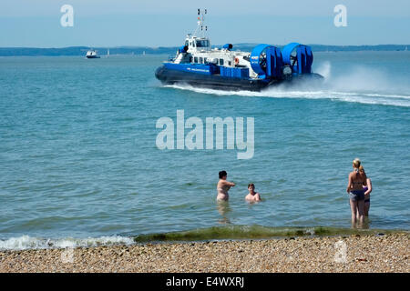 Quattro persone giocare nel mare come un hovercraft si allontana dal terminale in rotta per il Isle of Wight dopo una calda giornata di sole a Southsea Regno Unito Foto Stock