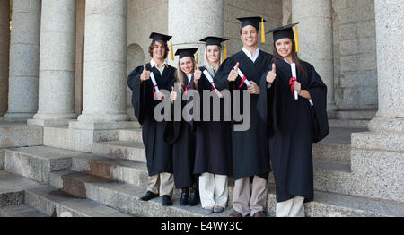 Cinque laureati felice ponendo il pollice-up Foto Stock