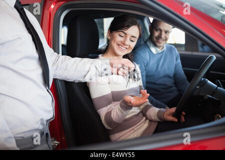 Venditore di dare le chiavi di una coppia sorridente Foto Stock