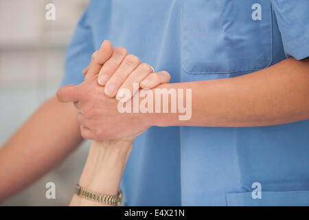 L'infermiera tenendo le mani della signora anziana Foto Stock