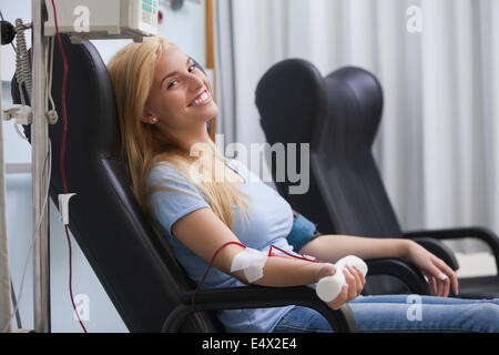 Donna sorridente la donazione del sangue Foto Stock