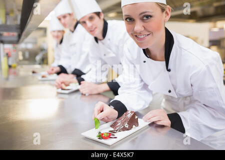 Lo Chef sorridente di finitura di piatti da dessert Foto Stock