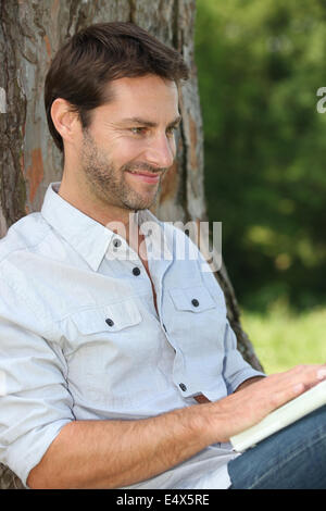 Uomo con notebook in posizione di parcheggio Foto Stock